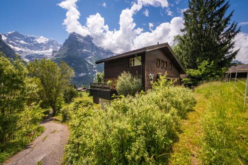 a house in the mountains with a dirt road at Luftschloss in Grindelwald