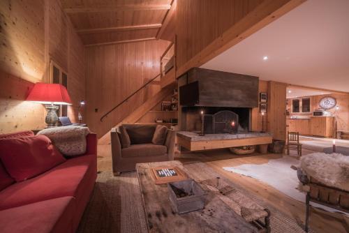 a living room with a red couch and a fireplace at Luftschloss in Grindelwald