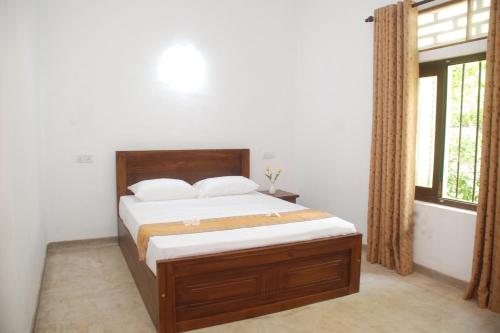 a bedroom with a bed and a window at Samudra Unawatuna in Galle