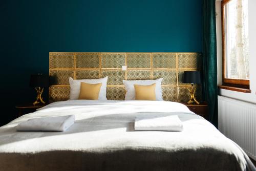a bedroom with a large bed with a blue wall at Villa Lulu Piaseczno in Piaseczno