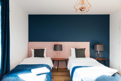 two beds in a room with blue and pink at Villa Lulu Piaseczno in Piaseczno