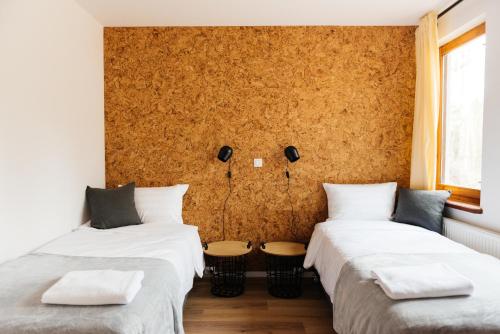 a room with three beds with white sheets at Villa Lulu Piaseczno in Piaseczno