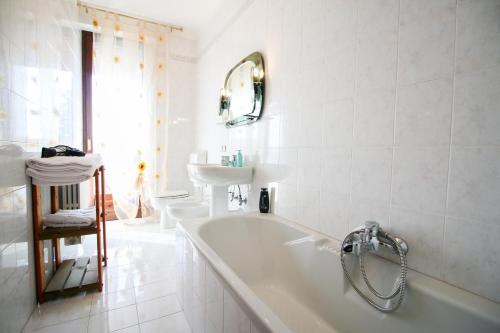 un bagno bianco con vasca e lavandino di Spighe Paglia e Girasole a Candia Canavese