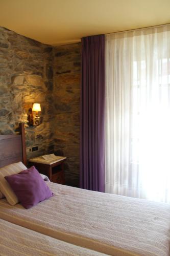 a bedroom with a large bed and a window at Hotel Casa Prendes in Cudillero