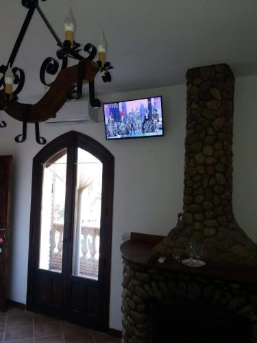a living room with a fireplace and a tv on the wall at Il Castello in Piazza Armerina
