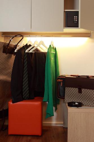a closet with a red chair and some clothes at Hotel Colonne in San Giovanni Rotondo