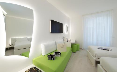 a white room with a green couch and a bed at AHD Rooms in Milan
