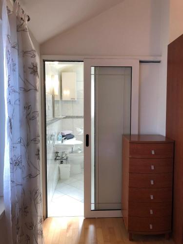 a bathroom with a glass door leading to a sink at Marko Apartment in Korčula