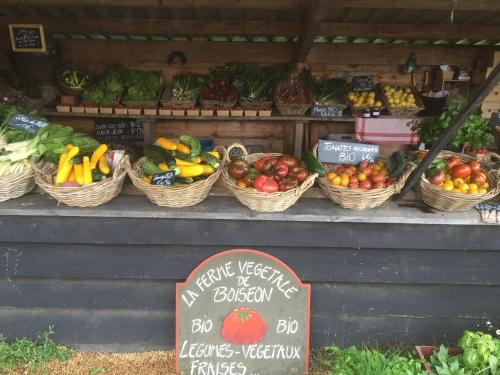 a fruit and vegetable stand with baskets of fruits and vegetables at Les crèches de Boiséon in Penvénan