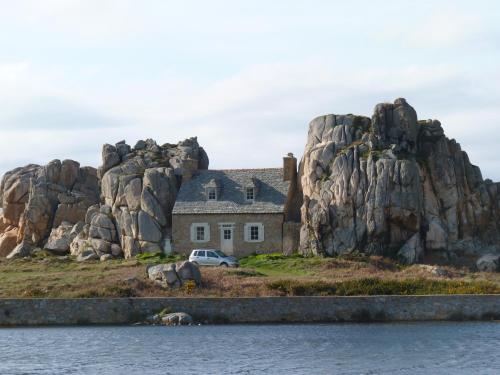 a house on a rocky island in the water at Les crèches de Boiséon in Penvénan