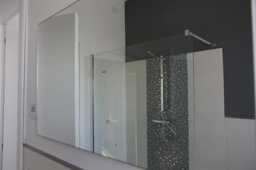 W łazience znajduje się prysznic ze szklanymi drzwiami. w obiekcie Il colore dei sogni w mieście Due Carrare