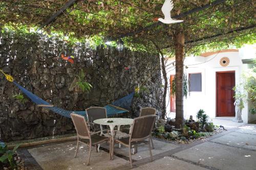 Un patio con mesa y sillas y un muro de piedra. en Las Mariposas Hotel & Studios, en Oaxaca City