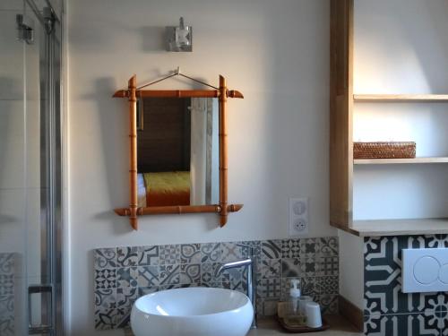 W łazience znajduje się umywalka i lustro. w obiekcie Chambres d'hôtes Le Clos Bleu w La Rochelle
