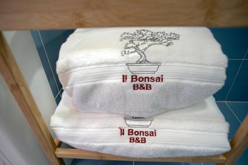 una pila di asciugamani con un bonsai sopra di Il Bonsai B&B a Roma