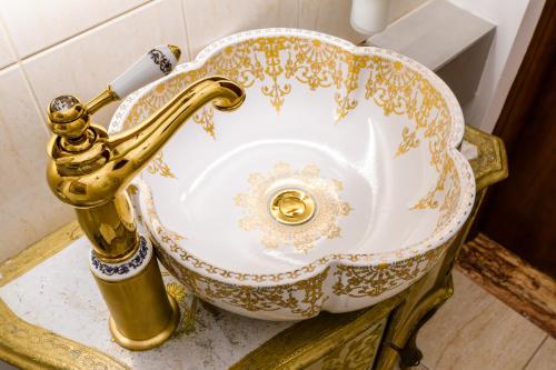 un lavandino con rubinetto d'oro in bagno di ClickTheFlat Palace Of Culture Art Apartment a Varsavia