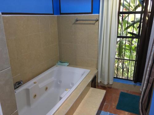 a bathroom with a bath tub and a window at Hacienda San Pedro Nohpat in M&eacute;rida