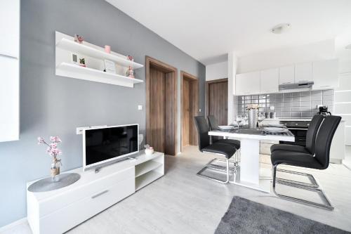 a living room with a table and chairs and a television at Deluxe Apartments Franić in Suko&scaron;an