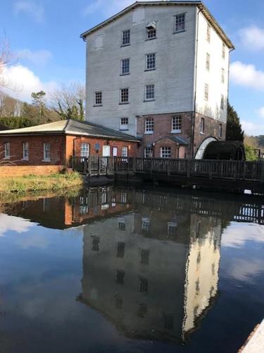 an old barn is reflected in a body of water at Maison Dieu Guest House in Dover