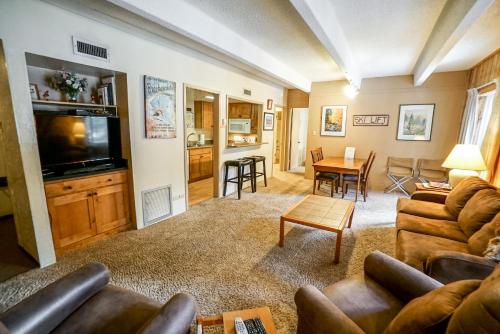 a living room with a couch and a tv and a table at Columbine North Star Condo: Close To Everything in Breckenridge