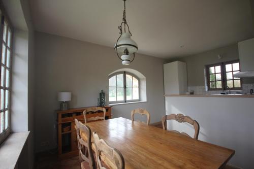 une salle à manger avec une table et des chaises en bois dans l'établissement La Bergerie du Domaine des Buissonnets, à Écardenville-sur-Eure