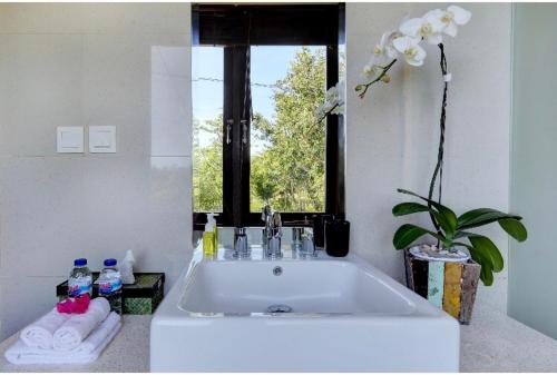 a bathroom with a large white sink and a window at Indah Balangan Villa in Jimbaran