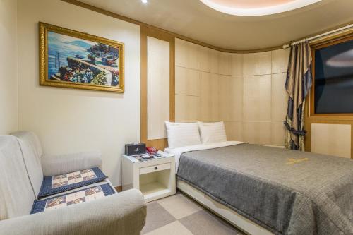 Incheon Airport Hotel في انشيون: غرفة صغيرة بها سرير وكرسي