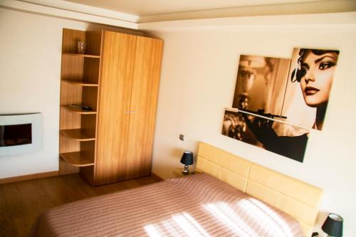 a bedroom with a bed and a wooden cabinet at Luxury apartment in the heart of the capital in Kyiv