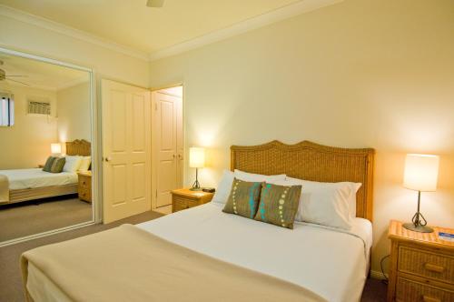 - une chambre avec un lit, deux lampes et un miroir dans l'établissement Central Plaza Apartments, à Cairns