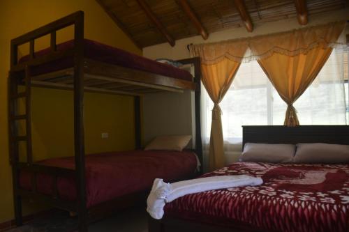 1 dormitorio con 2 literas y ventana en SOL DE PIEDRA, en Papallacta