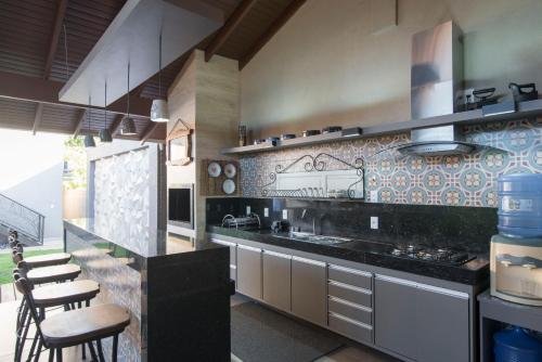 a kitchen with a counter with stools in it at Casa Temporada Castro Alves in Bonito