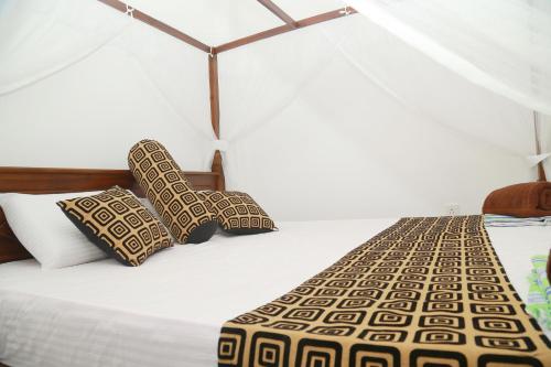 a white bed with two pillows on it at Happy Spring Guest in Mirissa