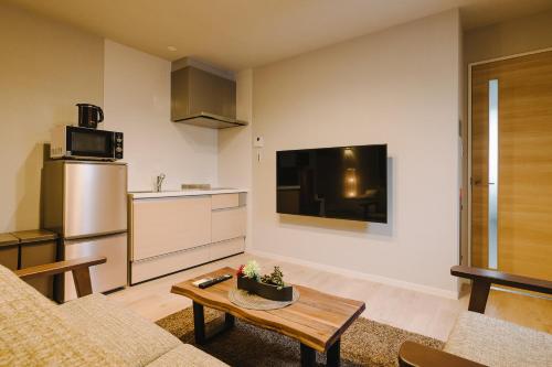 a living room with a couch and a table at GRAND BASE Karatsu Ekiminami in Karatsu