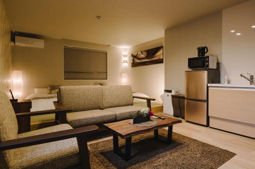 a living room with a couch and a table at GRAND BASE Karatsu Ekiminami in Karatsu