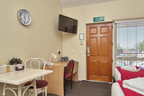 a room with a desk and a clock on the wall at Apollo Motel in Christchurch