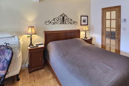 a bedroom with a bed and two lamps on tables at Gite Le Sieur de Joliette in Montréal