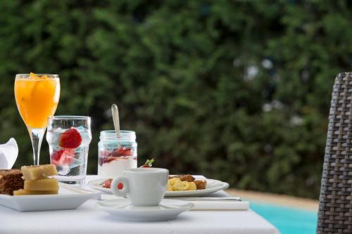 a table with a breakfast of fruit and a drink at Lagos Mare Hotel in Agios Prokopios