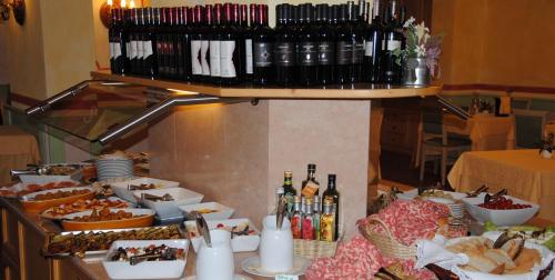 a buffet with food and bottles of wine on a table at Dolasilla Park Hotel in Vigo di Fassa