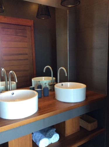two sinks in a bathroom with two mirrors at St Barth Villas in Salad Beach