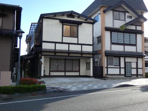 a white and black house on a street at Minpaku Suzuki in Hiraizumi