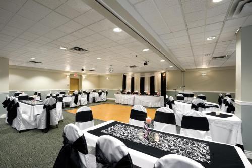a banquet hall with white and black tables and chairs at Harrison Lake Hotel in Harrison Hot Springs