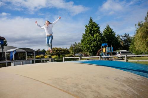 a girl jumping on top of a trampoline at Te Anau Top 10 Holiday Park and Motels in Te Anau