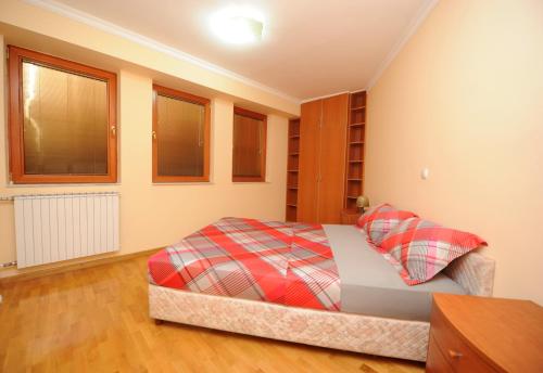 a bedroom with a bed with a plaid blanket at Exclusive Skopje Apartments in Skopje