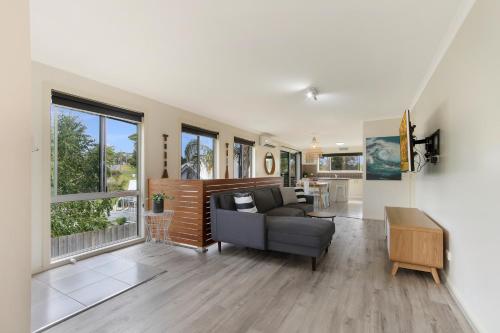 a living room with a couch and a table at Lake House - Cosy Coastal Getaway in Lake Tyers