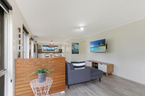 a living room with a chair and a table at Lake House - Cosy Coastal Getaway in Lake Tyers
