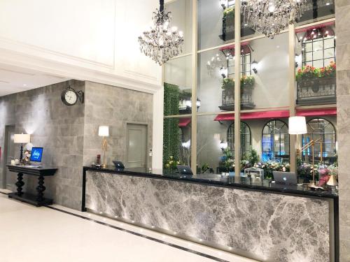 a lobby with a reception desk and a clock at Ashley Sabang Jakarta in Jakarta