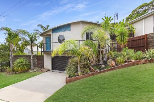 a house with a fence and a yard at Lake House - Cosy Coastal Getaway in Lake Tyers