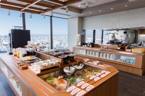a restaurant with a buffet with a view of the city at New Tomakomai Prince Hotel NAGOMI in Tomakomai