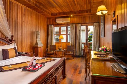 a room with a bedroom with a bed and a desk at Ta Prohm Hotel & Spa in Siem Reap