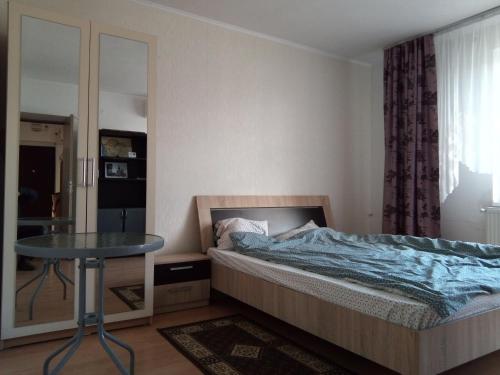 Schlafzimmer mit einem Bett, einem Tisch und einem Fenster in der Unterkunft Central Apartment 2 in Timişoara
