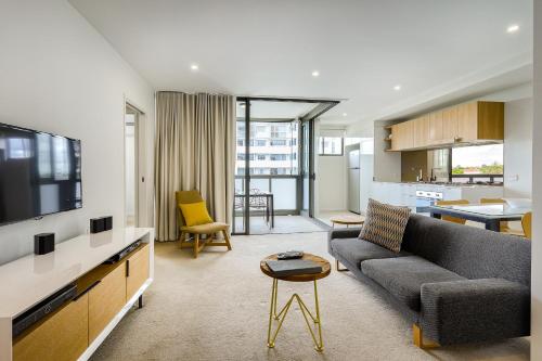 a living room with a couch and a tv at Vine Apartments South Brisbane in Brisbane